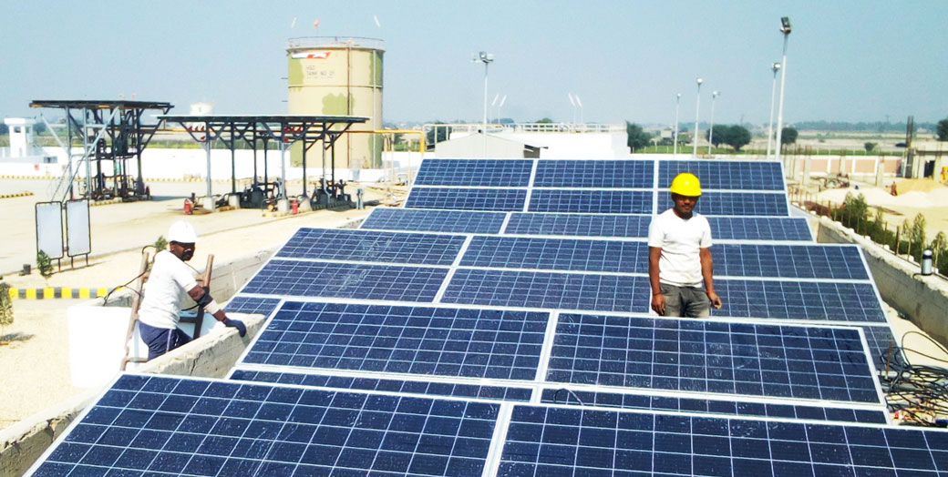 People working next to solar panels